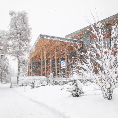 Scène d'hiver avec le bâtiment du palais à Megève et des arbres, tous recouverts d'une épaisse couche de neige.