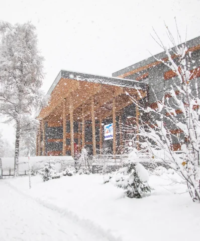 Scène d'hiver avec le bâtiment du palais à Megève et des arbres, tous recouverts d'une épaisse couche de neige.