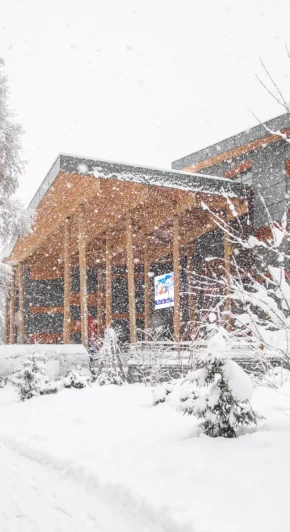 Scène d'hiver avec le bâtiment du palais à Megève et des arbres, tous recouverts d'une épaisse couche de neige.