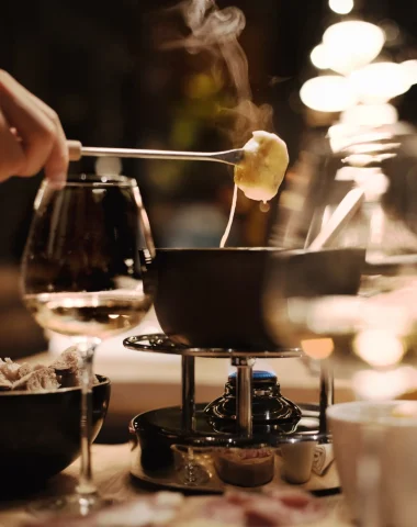 Plat de fondue avec un morceau de pain trempé dans le fromage fumant.