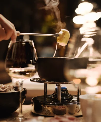 Plat de fondue avec un morceau de pain trempé dans le fromage fumant.